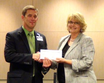Dr. Jim Hinson, Shawnee Mission superintendent, accepts a check from René Gillespie, SMEF board president.