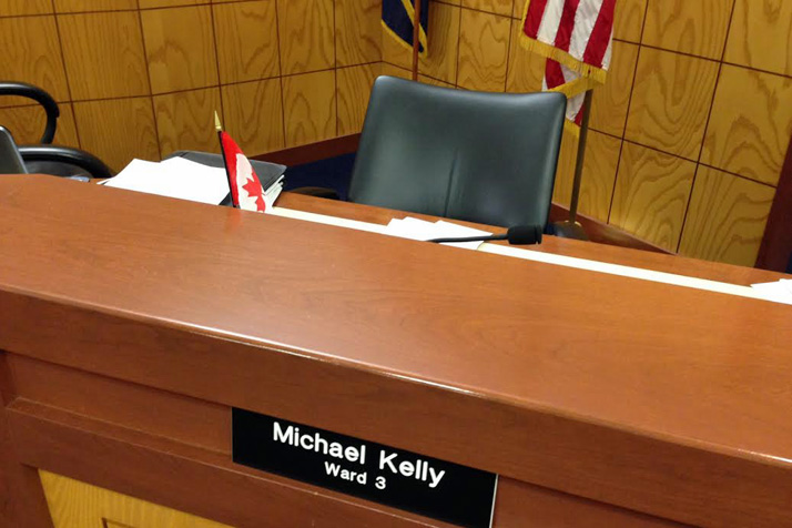 Someone planted a small Canadian flag on the desk of Michael Kelly's city council seat Monday.