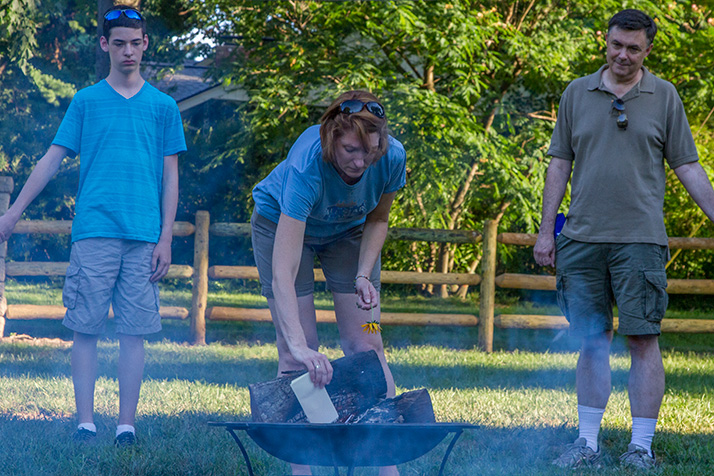 Sarah Higgins, the mother of Mark Harken, placed a note to her son in the flames of a fire pit Sunday evening at a vigil.