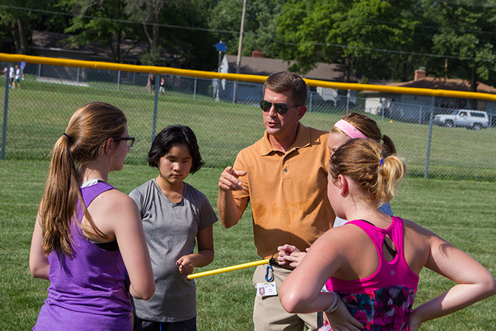 Mark Craig, in orange shirt, devised the guide tether Shemer uses at cross country practices and meets.