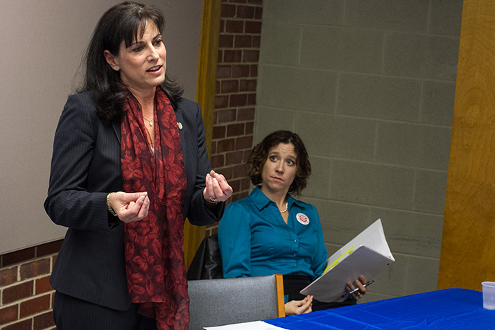 Incumbent Melissa Rooker, standing, and challenger Jennifer Robinson spoke before a crowd of approximately 40 at the Cedar Roe Library Thursday.