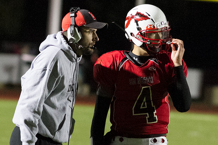 SM North coach Ben Bartlett consulted with quarterback Will Schneider in the first half.