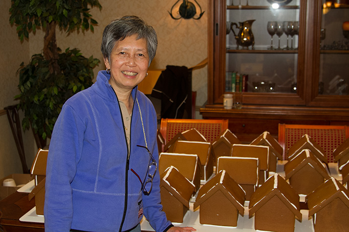 Mely Ballard bakes and assembles the gingerbread houses for the party.