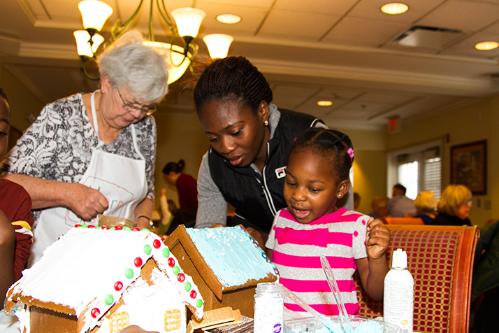 Teni Oyetunji, 3, was all smiles as she decorated her gingerbread house with the help of her mother Kiki.