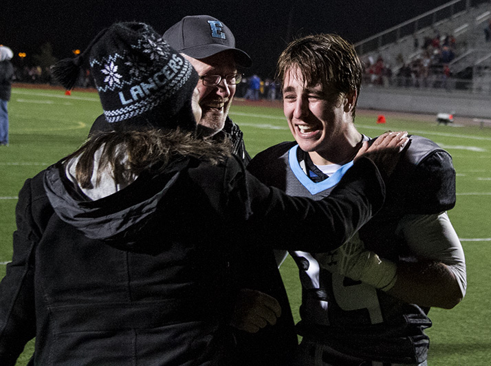 Sam Huffman hugged his parents, Doug Huffman and Mary Sinclair, after his gutsy two-point conversion run pushed the Lancers past Olathe North in the substate game in 2014.