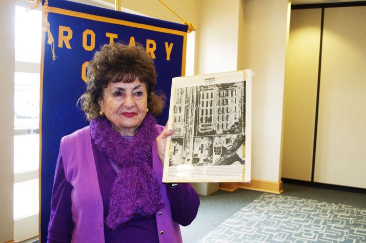Sonia Warshawski with an aerial photo of the camp at Auschwitz-Birkenau taken by allied planes.