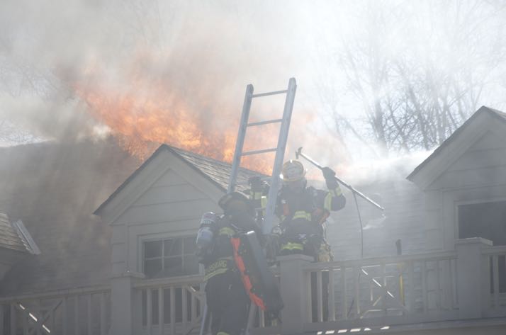 Flames popped back out of the roof at the Mission Hills home, forcing firefighters to evacuate the third floor and return to a defensive technique.