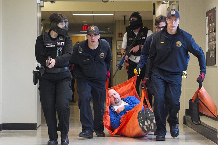 Police officers escorted fire fighters as they carried a wounded victim out of the building in the active shooter simulation.