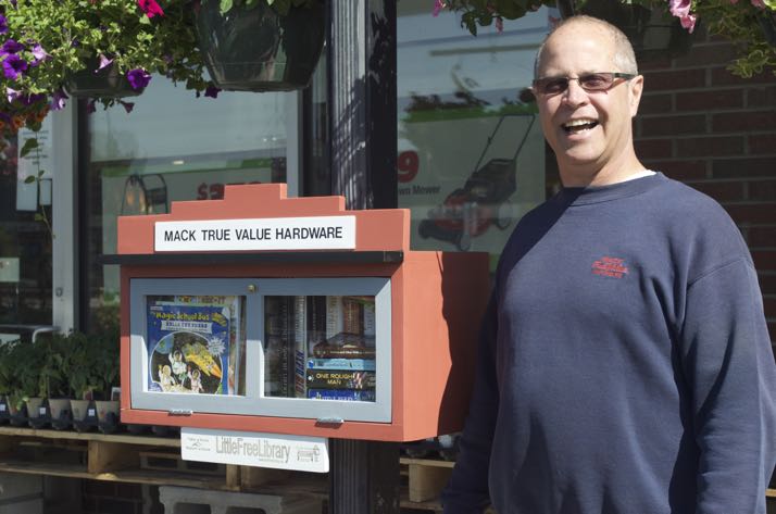 Kelly Mack of Mack Hardware on Johnson Drive and the store's Little Free Library.