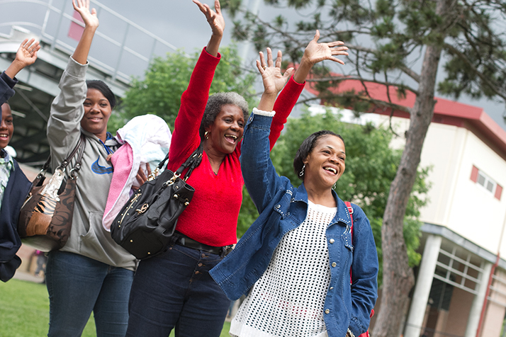 Regina Porter, in red, and Phyllis Bailey, in jean jacket, wave to their granddaughter Dariece Bailey.