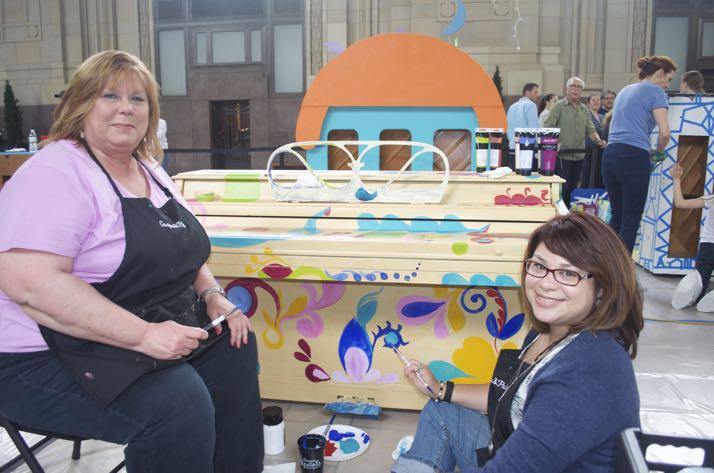 Christine Webster and Lanee Morales decorate the Roeland Park piano over the weekend at Union Station.