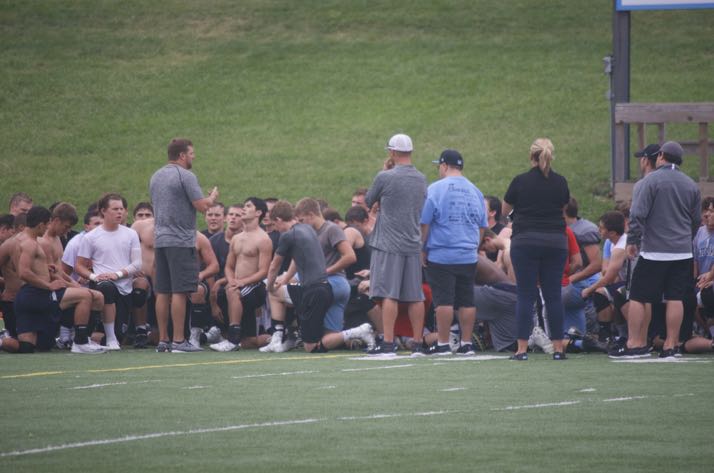 Team members huddle around coach Dustin Delaney.