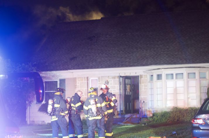 Smoke can be seen on the back side of the house coming from the attic.