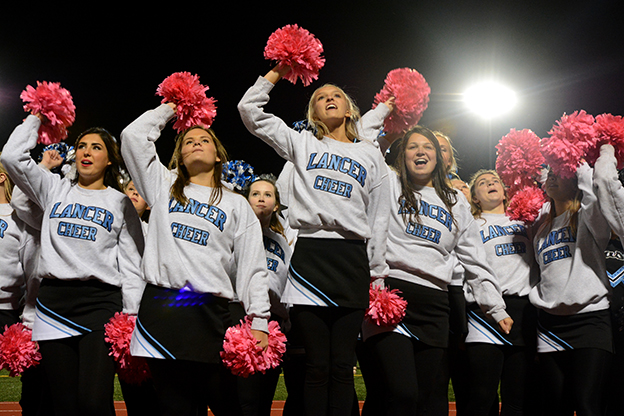 Senior Audrey Dickens leads varsity cheerleaders in the school song after an overwhelming loss to the Firebirds. Photo by Joseph Cline
