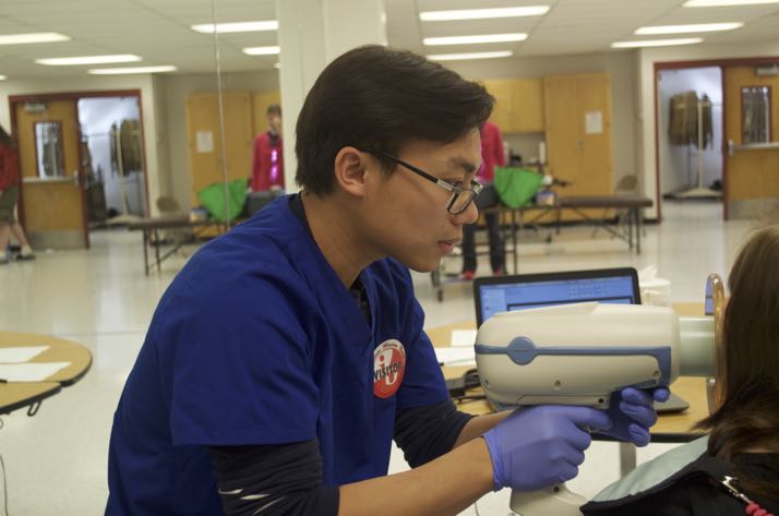 Dental technician Vin Truong takes X-rays of a student during the dental clinic this week at SM North.