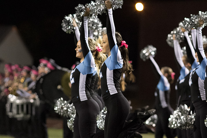 The Lancer Dancers cheered as the football team ran onto the field.