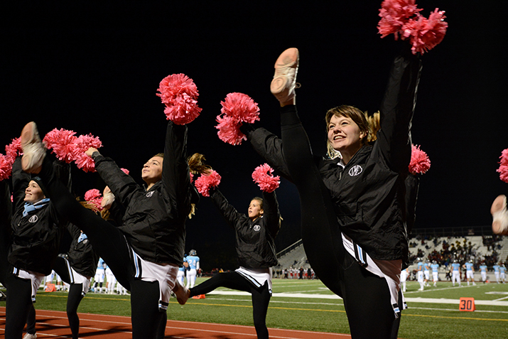 Senior Maggie Brophy performs a high kick to amp up the student section. Photo by Joseph Cline