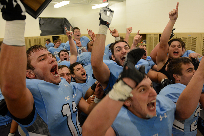Senior Charlie Jensen celebrates with teammates by jumping around in the locker room with the 2015 6A Kansas Regional Champs plaque. Photo by Joseph Cline.