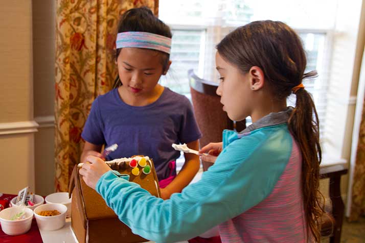 Amelie and Isabelle Wong of Prairie Village set to work decorating their houses at Brighton Gardens Sunday.