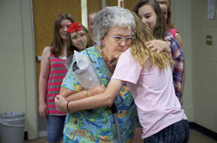 Lillie May gets hugs from members of the Indian Hills choir Friday.