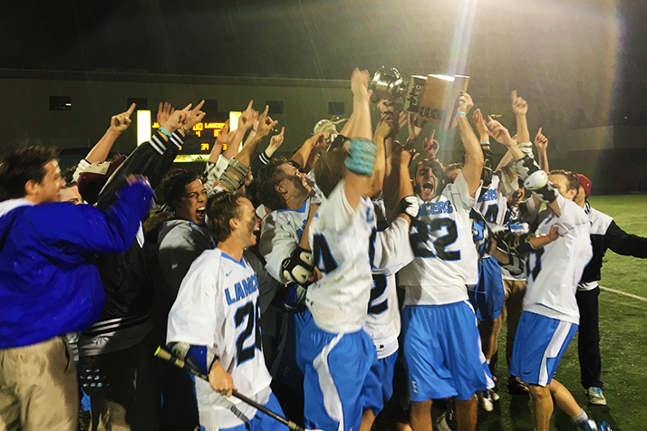 Senior Will Kost hoists the LAKC title cup after the Lancers beat Blue Valley West 18-11 in the finals.