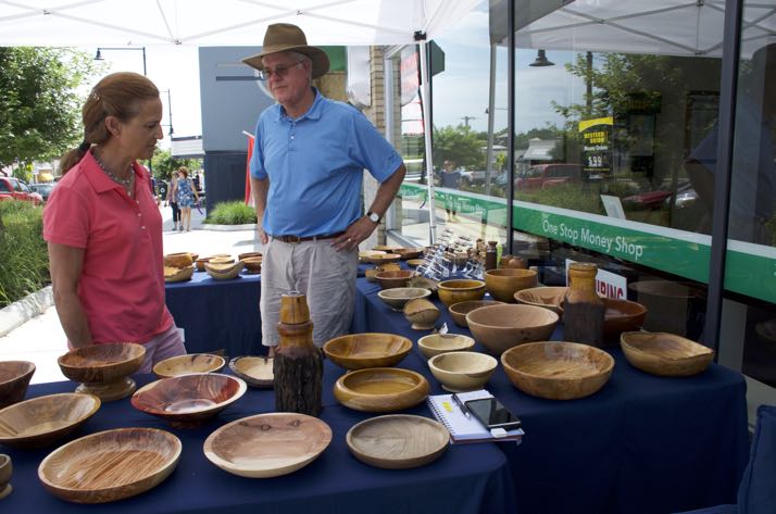 Carl Brooks showed his wooden bowl creations to a shopper Saturday on Johnson Drive.