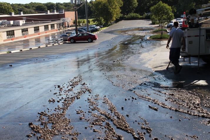 Water gushing from a damaged fire hydrant cascaded through adjoining parking lots.