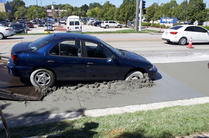 A wrecker begins pulling the car out of the cement on Roe.
