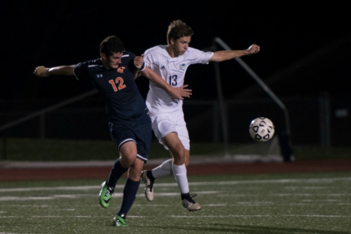 Lancer senior center back Taylor Stover holds off a Olathe East's Adrian Blanco Tuesday evening. The Lancers lost the game 1-0 on header off a free kick.