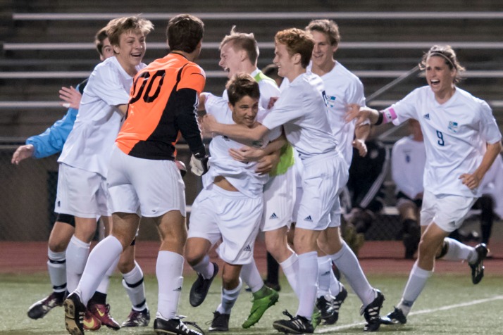 Teammates mob senior Oliver Bihuniak after he scored the golden goal Thursday evening against Blue Valley Northwest to win the regional championship. (Photo by Carrie Armstrong)