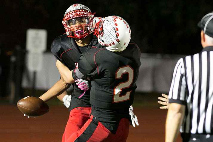 Quarterback Will Schneider hugs Avante Williams after the receiver roped in his second touchdown reception of the night.