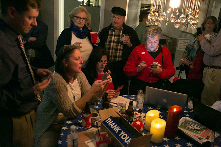 Melissa Rooker, center in glasses, checked early results Tuesday with supporters.