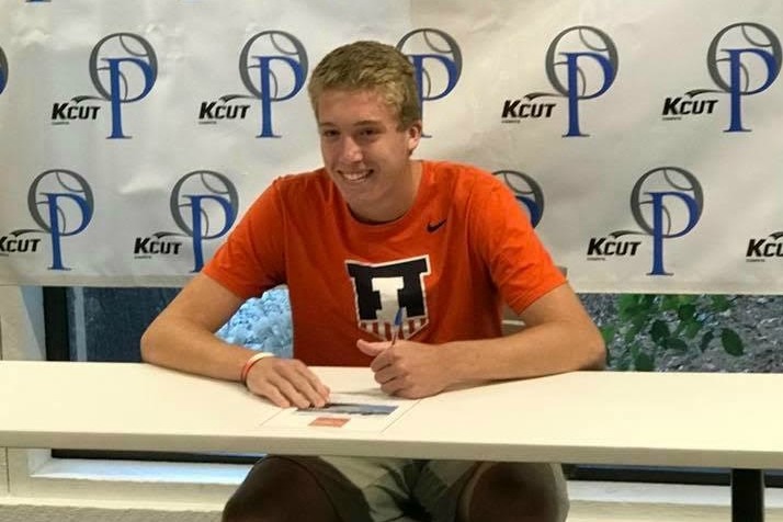 Shawnee Mission East senior Alex Brown signs his ceremonial letter of intent to play tennis at Illinois.