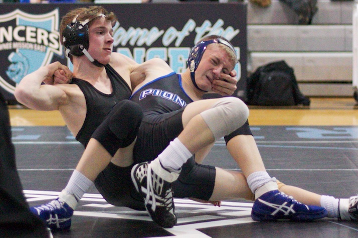 Shawnee Mission East's Dane Erickson has a handful of Leavenworth's Sean Becker's face.