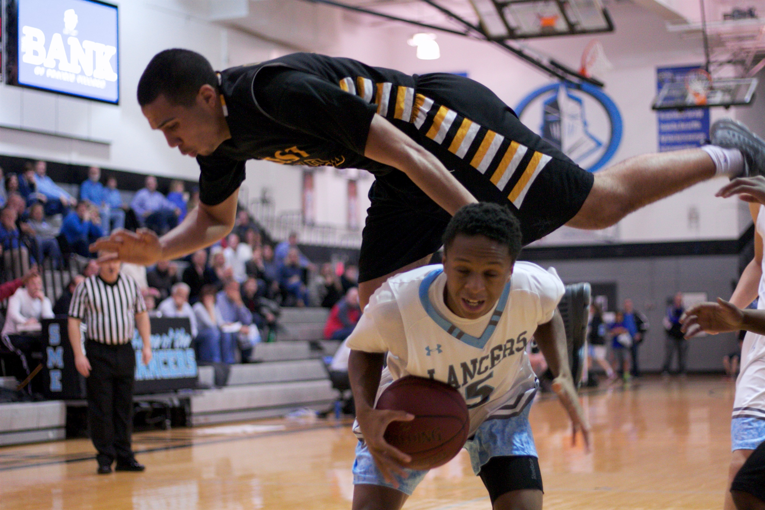 SM West guard Cameron Southern goes over the top of SM East's Kelyn Bolton. SM West was flying all over the place defensively in the first half.