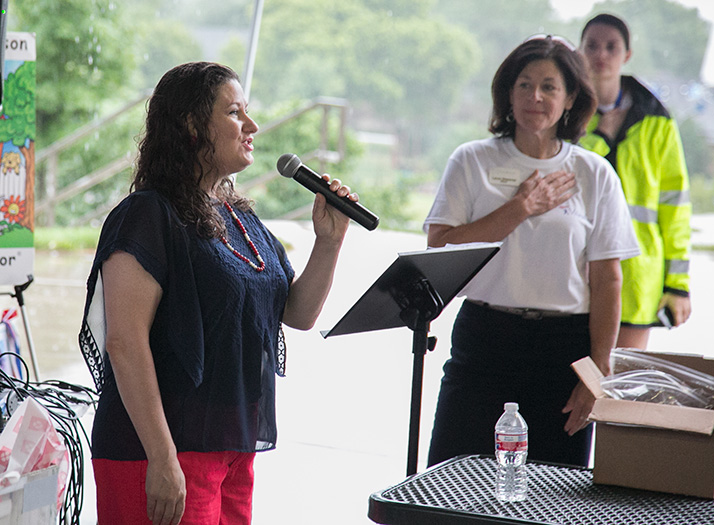 Kristy Lambert sang the National Anthem as the rains fell around Harmon Park Pavilion Tuesday morning.