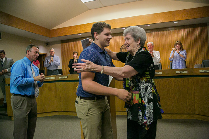 Mission city councilwoman Suzie Gibbs gives SM North student council president Cameron Peck a hug after he presented the city with a check for its Holiday Adoption Program.