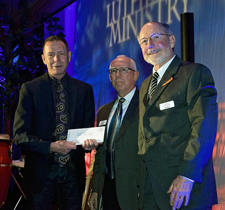 Bob Lindeblad of Faith Lutheran presents a check to Metro Lutheran Ministries. Photo courtesy MLM.