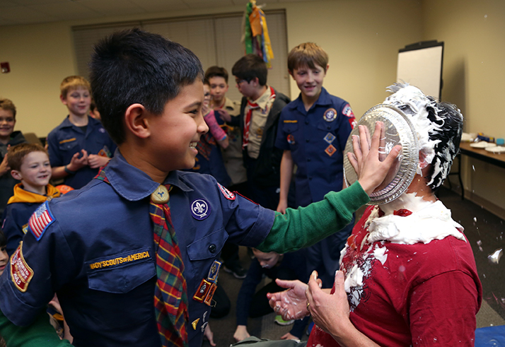 Scout Carson Graves shoves a pie into the face of leader Kory Lewis. Photos by Christopher Smith.